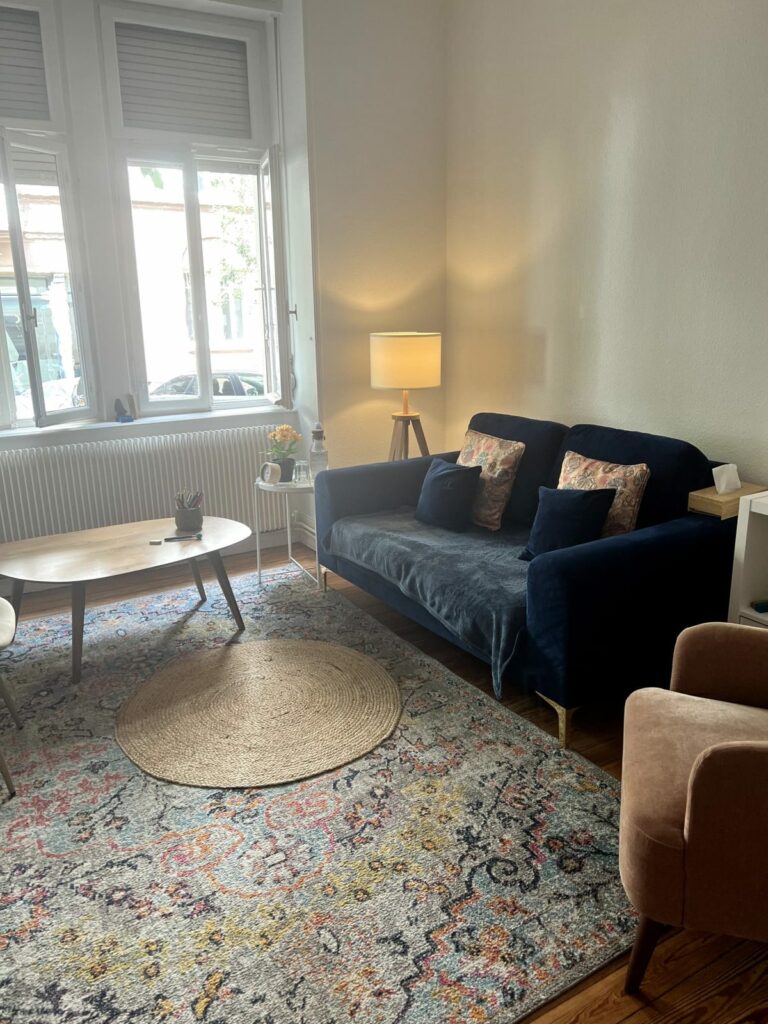 Cabinet de psychologie à Strasbourg : canapé bleu, lampe et table basse en bois